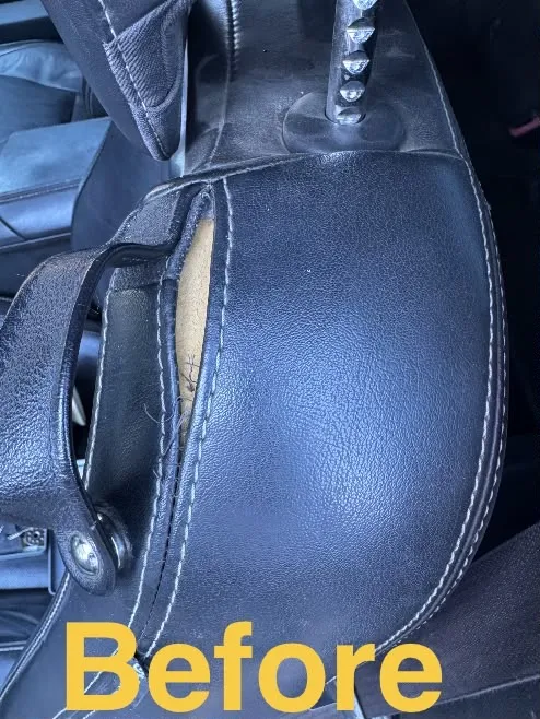 Black leather car armrest split open along the seam, with padding showing